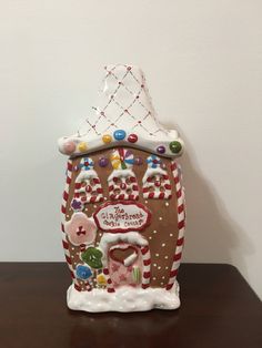 a gingerbread house with candy and candies on the roof is shown in front of a white wall