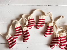 red and white knitted mittens hanging from strings