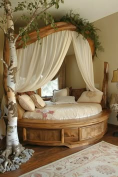 a canopy bed with curtains and pillows on top of it in a bedroom next to a tree