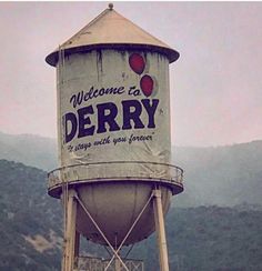 an old water tower with the words welcome to derby painted on it's side