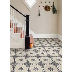 an entryway with stairs and decorative tiles on the floor