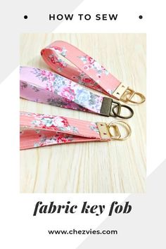 the fabric key fob is pink with flowers on it and has gold metal hardware