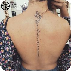 the back of a woman's neck is shown with flowers on it and an inscription written in cursive writing