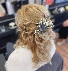 the back of a woman's head with flowers in her hair at a salon