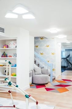 a room with white walls and colorful rugs on the floor in front of stairs