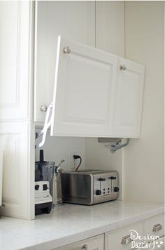 a kitchen with white cabinets and appliances on the counter