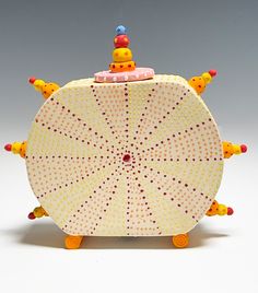 a yellow and white umbrella shaped box with orange handles