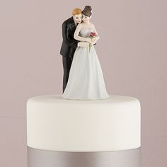 a bride and groom figurine on top of a wedding cake