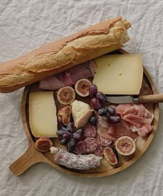 an assortment of cheeses, meats and bread on a plate