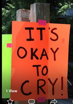 an orange sign that says it's okay to cry