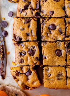 chocolate chip cookie bars cut into squares and placed next to an orange