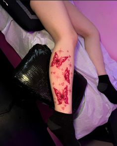 a woman's leg with red butterflies on it and her legs covered in black stockings