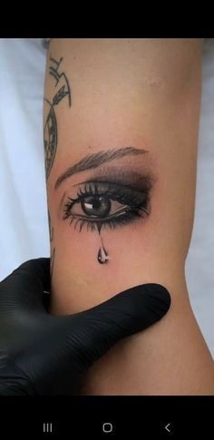 a woman's arm with an eye tattoo on it