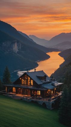 a large house sitting on top of a lush green hillside next to a body of water