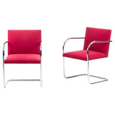 two red chairs sitting next to each other on top of a white floor and one has a metal frame