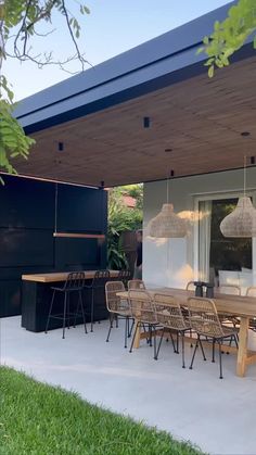 an outdoor dining area with wooden table and chairs