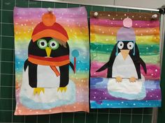 two towels with penguins on them hanging from the side of a bathroom wall next to each other