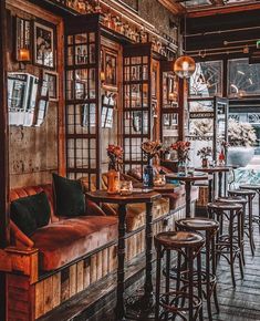 the interior of a restaurant with wooden tables and stools