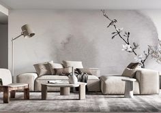 a living room with couches, tables and chairs in front of a wall mural