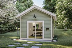 a small green shed sitting on top of a lush green field