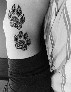 black and white photo of dog paw tattoo on the left side of the right arm