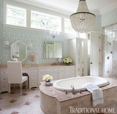 a large bath tub sitting under a chandelier in a bathroom