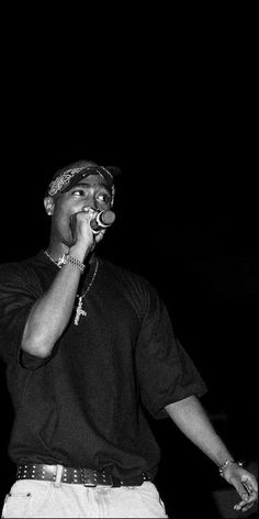 a black and white photo of a man talking on a cell phone in the dark