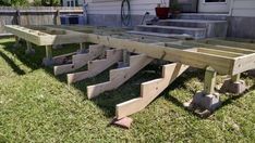 several wooden benches sitting in the grass next to a house