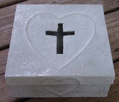 a white box with a black cross in the shape of a heart on top of it