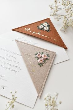 wedding stationery and envelopes laid out on top of each other, with flowers