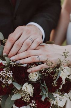 the bride and groom are holding hands with their wedding rings on top of each other