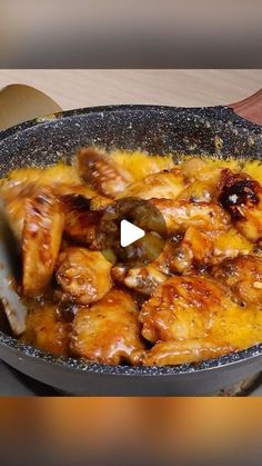 a pan filled with chicken and olives on top of a stove