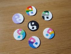 six different colored buttons sitting on top of a wooden table