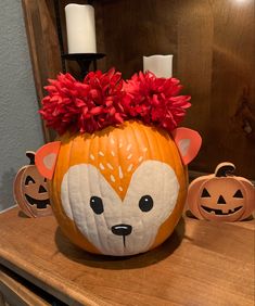 a pumpkin decorated like a fox with flowers in it