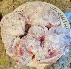 several pieces of meat on a plate covered in powdered sugar