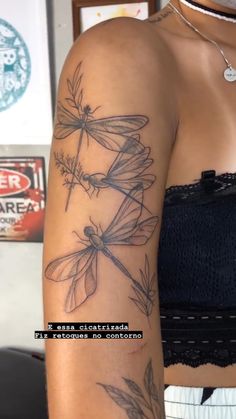 a woman's arm with dragonflies on it