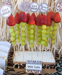 strawberries and grapes are arranged on sticks