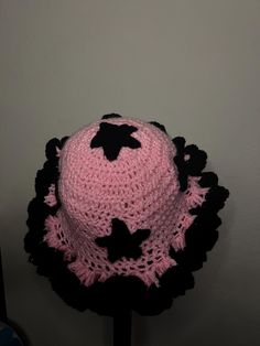 a pink and black crocheted hat with stars on it