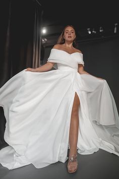 a woman in a white dress is posing for the camera with her legs spread out