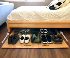 there are many pairs of shoes on the floor in front of a bed with a cow print pillow