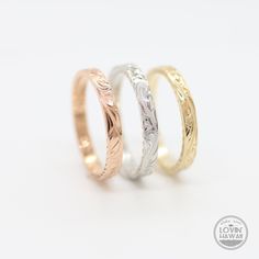 three different colored gold and silver rings on a white background with the words love written in it