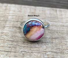 Choose your stone for this stunning dahlia turquoise sterling silver ring! These stones are orange, blue, purple, pink, and copper in color and have been set in sterling silver with a handmade ring band from sterling silver half dome wire. Each stone is 12mm in size. Made to order! Choose your stone and size for a custom ring! Please note that the stock rings are only available in the listed sizes below. Stock Ring 1 sizes 8-8.5. Stock Ring 2 sizes 6-6.5. Stock Ring 3 sizes 7.5-8. These turquois Multicolor Opal Gemstone Ring Gift, Multicolor Turquoise Round Ring For Anniversary, Multicolor Turquoise Ring For Anniversary, Multicolor Round Cabochon Gemstones, Artisan Multicolor Turquoise Ring, Multicolor Turquoise Ring With Natural Stones In Sterling Silver, Multicolor Natural Stone Turquoise Ring In Sterling Silver, Multicolor Natural Stones Turquoise Ring In Sterling Silver, Multicolor Natural Stones Sterling Silver Rings