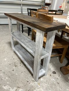 a table made out of wood and metal with chairs around it in a garage area