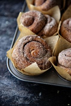 several pastries sitting on top of brown paper wrapped in wax paper and placed on a metal tray