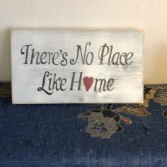 there's no place like home sign sitting on a blue chair with floral fabric