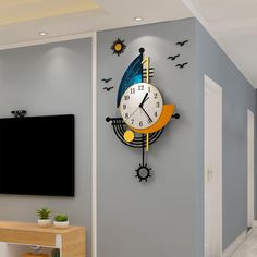 a large clock on the wall in a living room with birds and bats around it