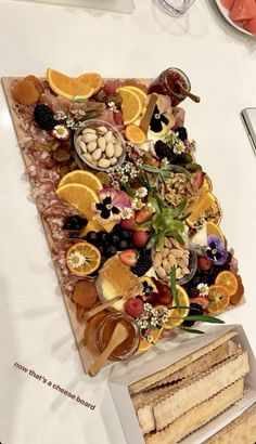 a platter with fruit, nuts and crackers on it