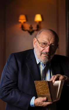 a man in a suit and tie holding an open book