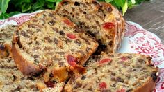 slices of banana bread on a red and white plate with green plants in the background