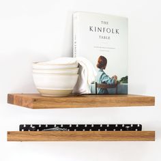 a book and bowl are sitting on two shelves